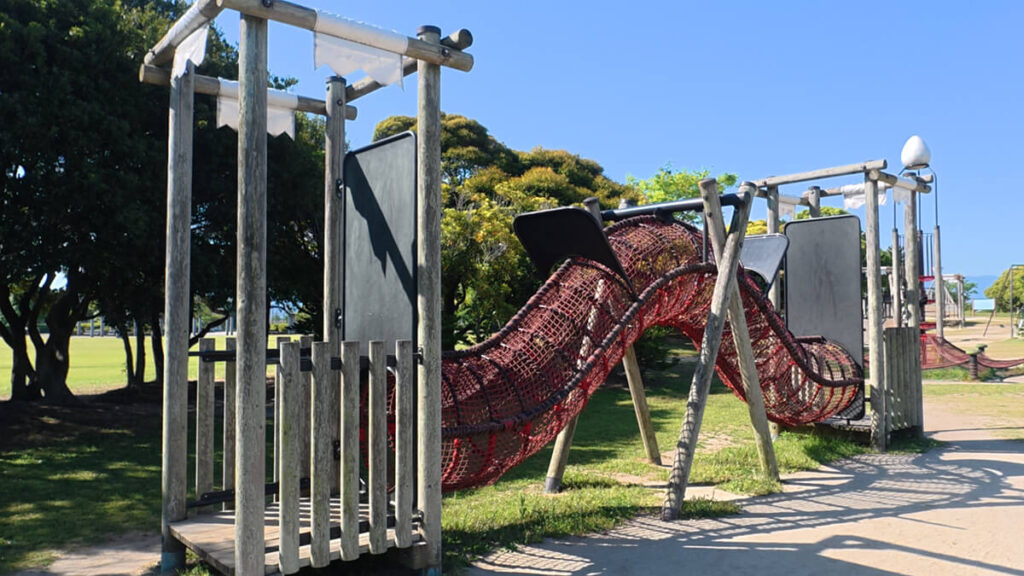 今津運動公園のアスレチック広場にある「トンネルアドベンチャー」。木製の足場と、うねるように続く赤いネットの筒型トンネル遊具。