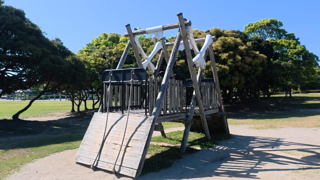 今津運動公園のアスレチック広場にある「クライムログアドベンチャー」。2本のロープを使って木製の傾斜板をよじ登るアスレチック遊具。