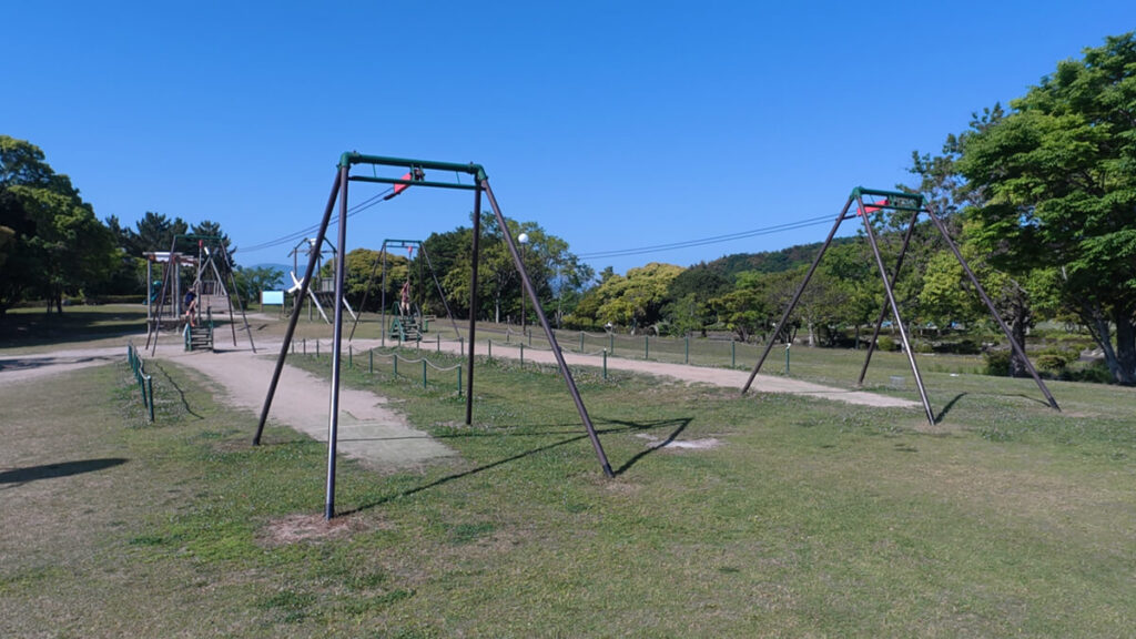 今津運動公園のアスレチック広場にある「ターザンアドベンチャー」。緑色のフレームに張られた長いロープを滑り降りるターザンロープ遊具。