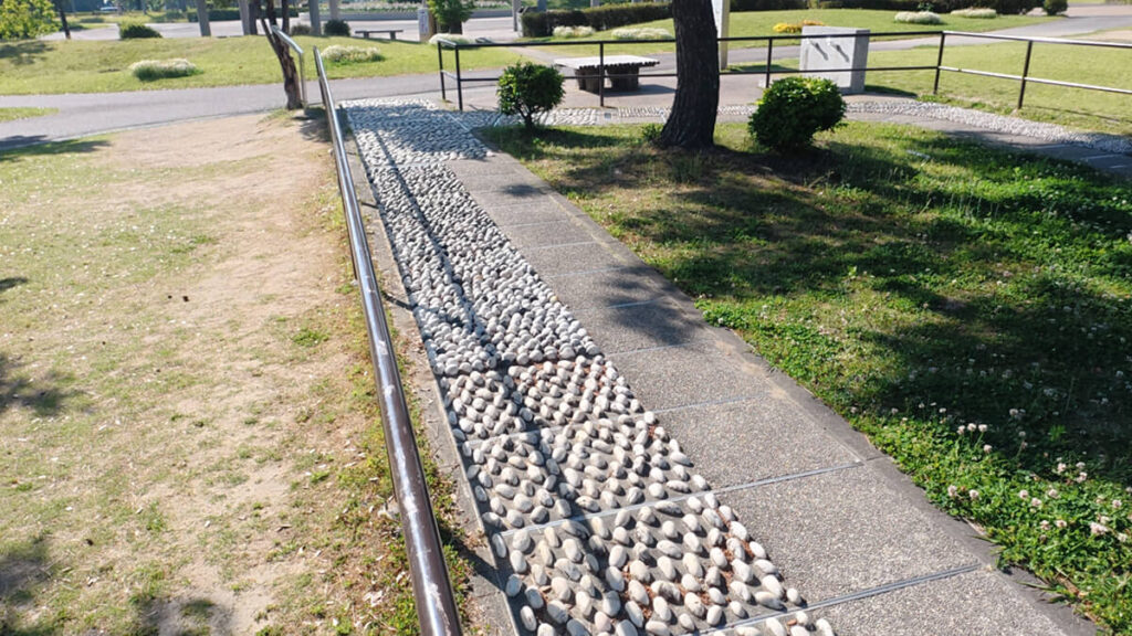 今津運動公園のリフレッシュロード。木陰の下を真っ直ぐに伸びる、白い「大きい玉砂利（Aエリア）」が敷き詰められた直線コースの風景。