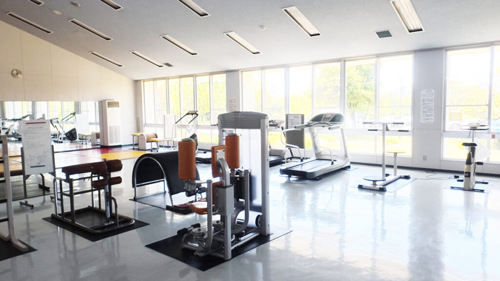 今津運動公園体育館のトレーニングルーム室内。ランニングマシンや筋トレ器具が充実し、大きな窓から光が差し込む。