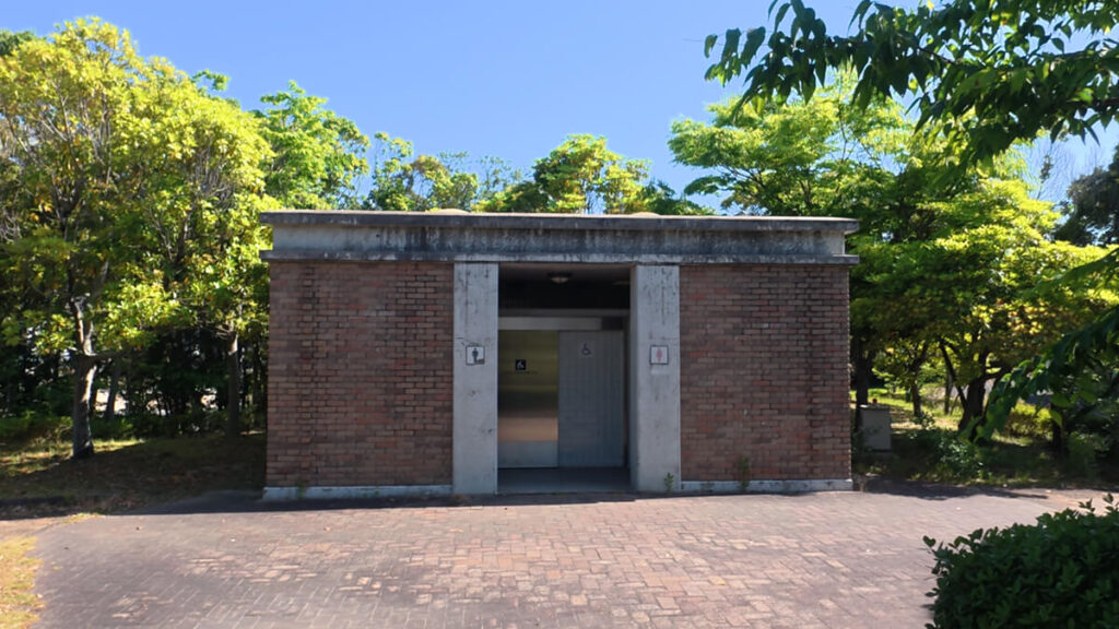 今津運動公園のテニスコート（クラブハウス付近）にあるレンガ造りの公衆トイレ外観。中央に多目的トイレの入り口がある。