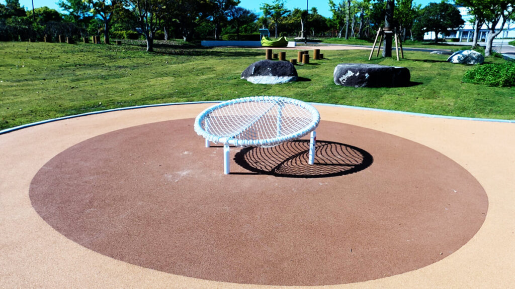 今津運動公園のインクルーシブ遊具エリアにある、皿型をした白いハンモック状のネット遊具。