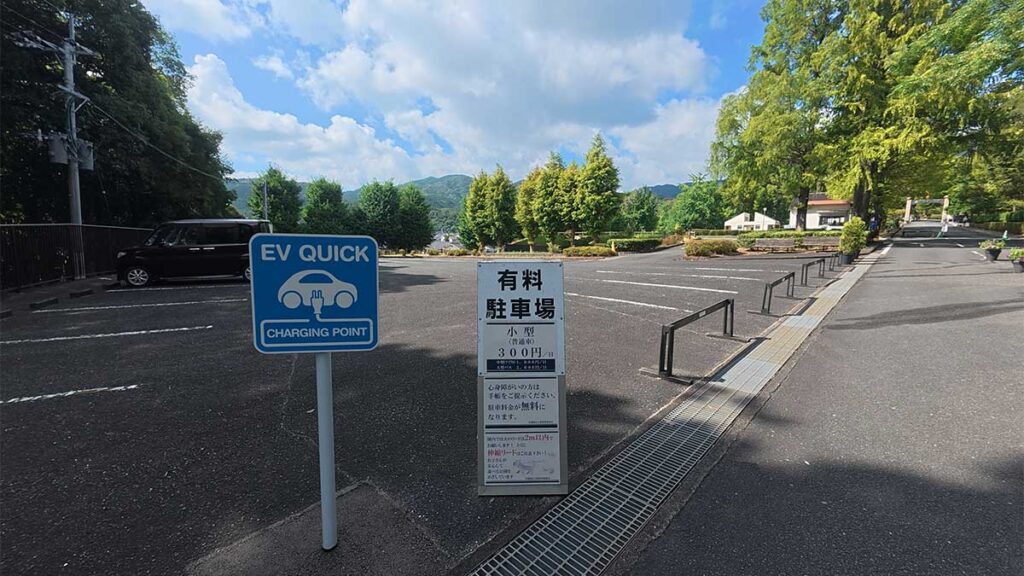 花畑園芸公園の東駐車場にある普通車1日300円の料金案内と電気自動車用充電設備