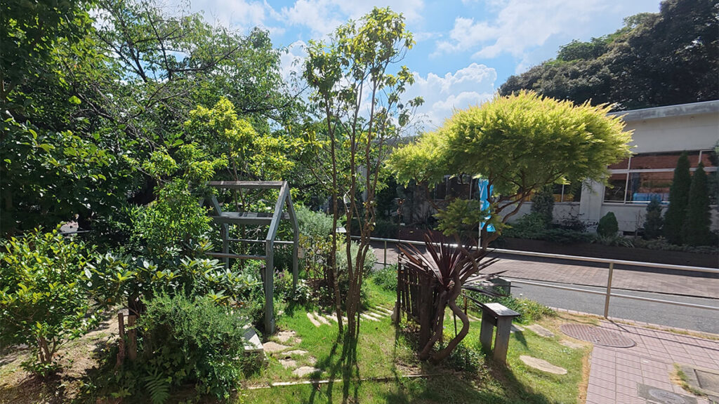 花畑園芸公園のキッズガーデンに植えられた樹木や草花と、小さなアーチ