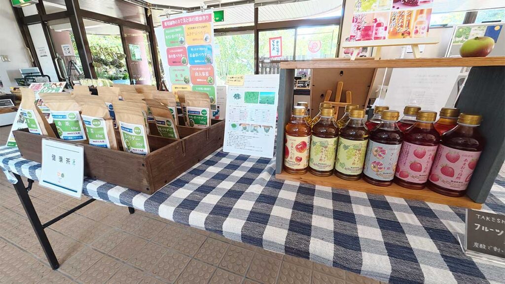 花畑マルシェの売り場に並ぶ袋入りのお茶と、果物を使ったフルーツビネガー