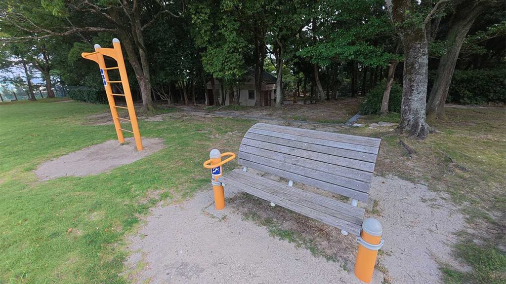 花畑園芸公園の芝生広場にある、ベンチとオレンジ色の健康遊具