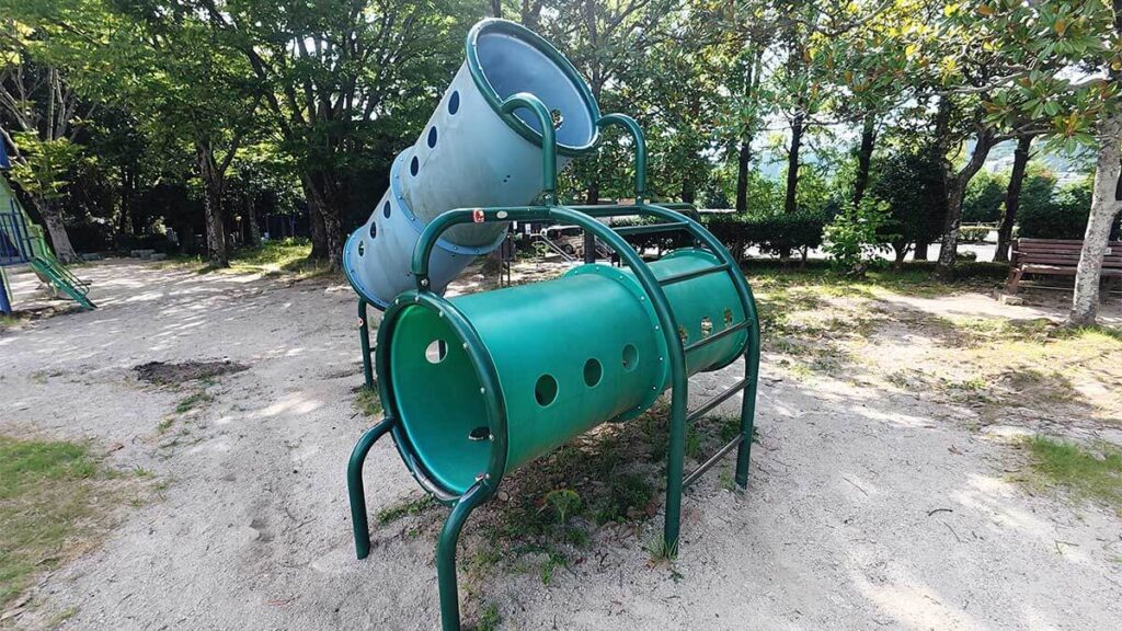 花畑園芸公園の遊具広場にある、丸い穴が開いた緑色のトンネル型遊具