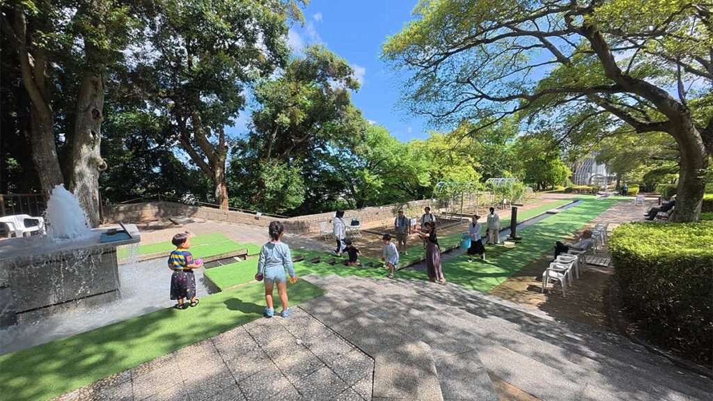 花畑園芸公園のカスケード広場で、噴水から続く水路の近くで遊ぶ子どもたち