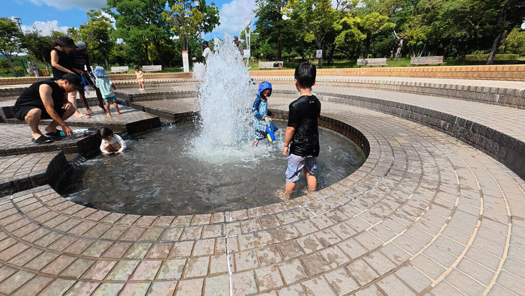 白水大池公園の噴水で水遊びをする子どもたち。浅い水場で夏に涼みながら遊べる