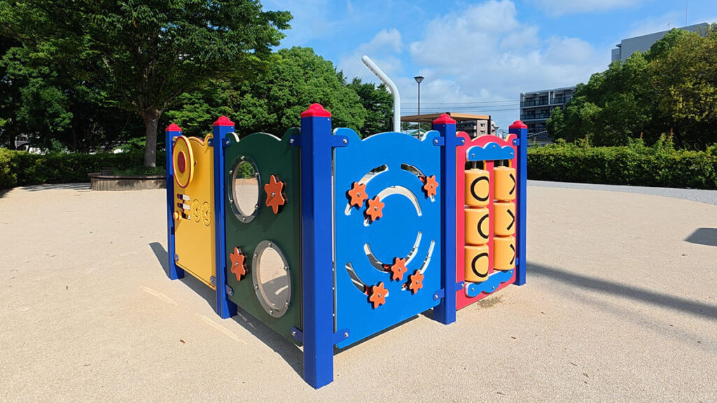 福岡市南区の桧原運動公園にある幼児向け遊具パネル。歯車や丸窓、絵合わせで遊べるカラフルな遊具