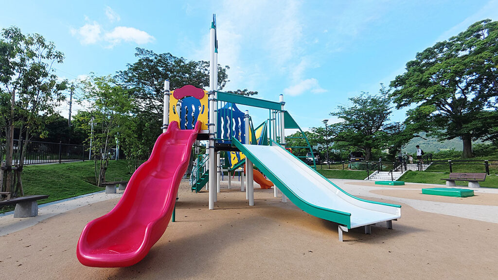 福岡市南区の桧原運動公園にある大型複合遊具のすべり台。赤いカーブすべり台と幅広い白いすべり台が並んでいる