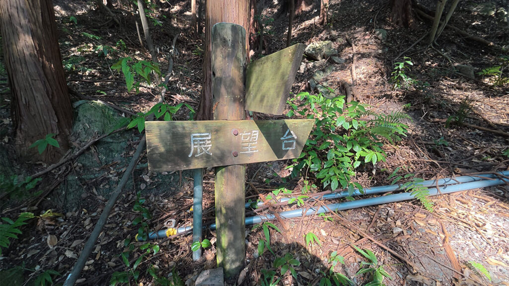 柏原公園の森林内に設置された、展望台の方向を示す木製の案内標識