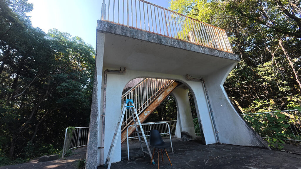 柏原公園の林の中に建つ、屋上へ上がる金属製階段を備えたコンクリート製展望台
