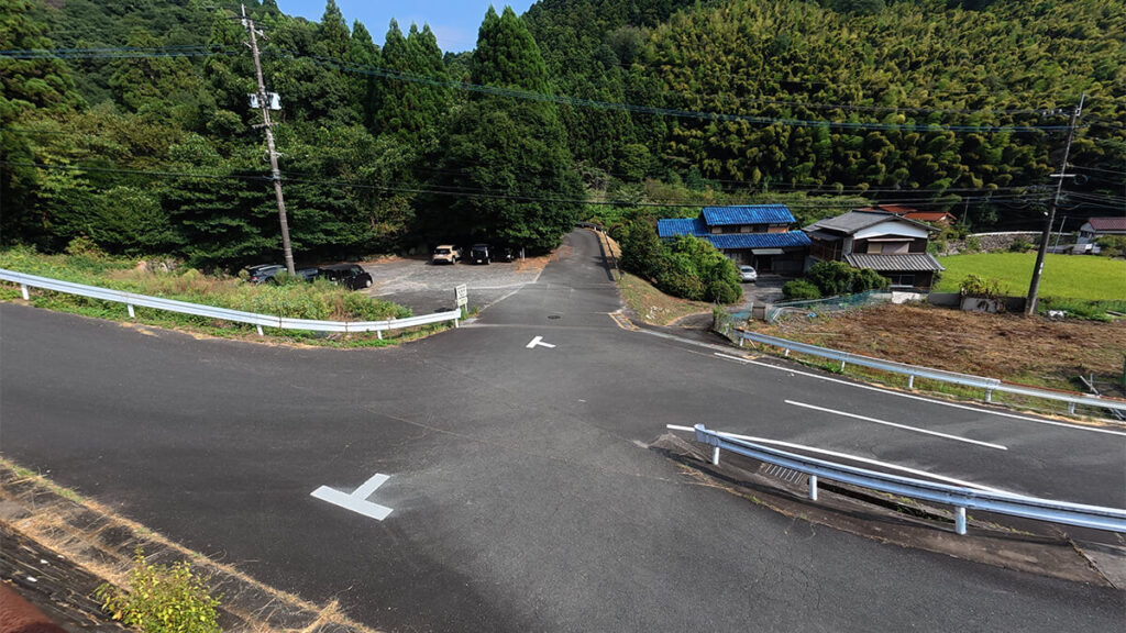 道路の上から見た野河内渓谷の無料駐車場と入口へ続く分岐