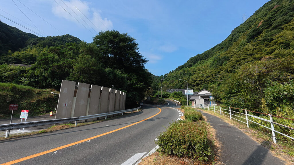 無料駐車場から野河内渓谷入口へ向かう国道263号沿いの歩道と右手奥の上り坂